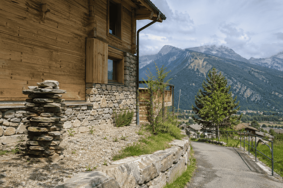 Panneau en bois et pierre naturelle avec paysage montagneux en arrière-plan.